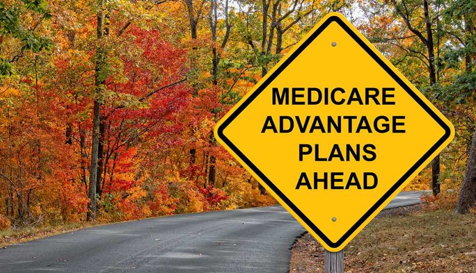 Carretera con árboles de otoño y un letrero vial que dice planes  
Medicare Advantage adelante
