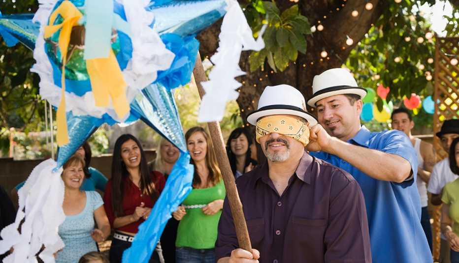Adultos rompiendo una piñata