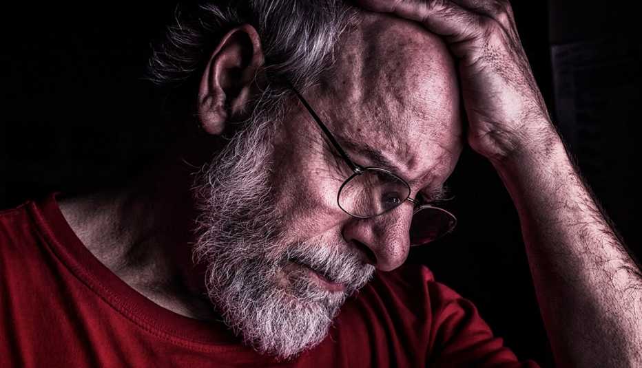 Hombre con su mano en la cabeza, deprimido