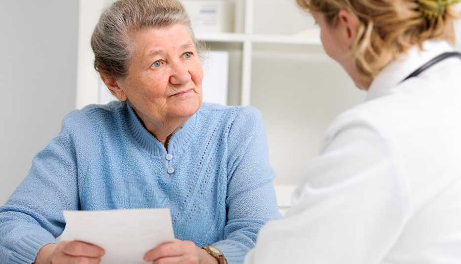 Una mujer sostiene un papel con preguntas para su doctora