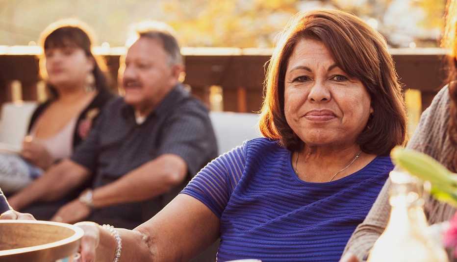 Mujer disfruta de una comida al aire libre con otras personas
