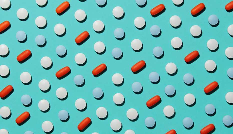 Pastillas de diferentes formas y colores sobre un fondo turquesa