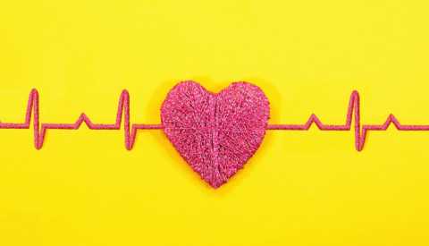 Latidos del corazón que forman un corazón al centro sobre un fondo amarillo