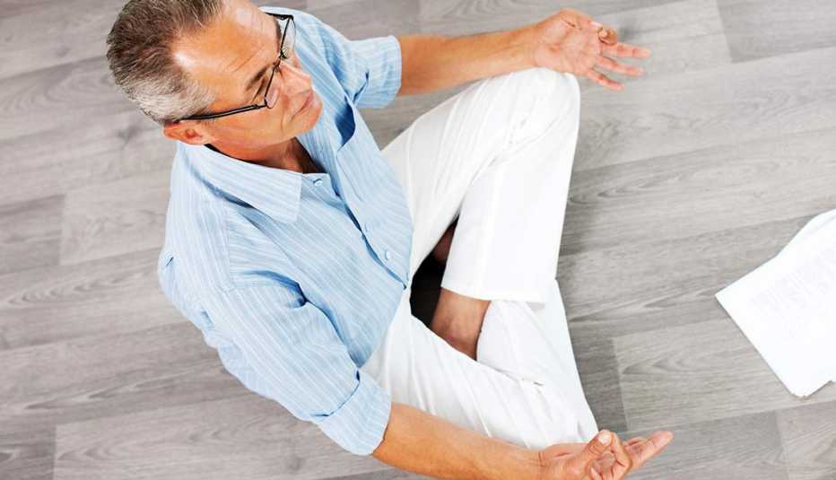 Hombre sentado meditando - Beneficios de la meditación