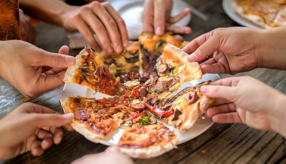 Varias personas comparten una pizza