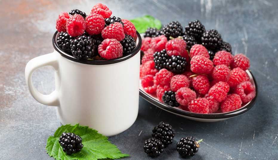 Variedad de moras en una taza y en un plato