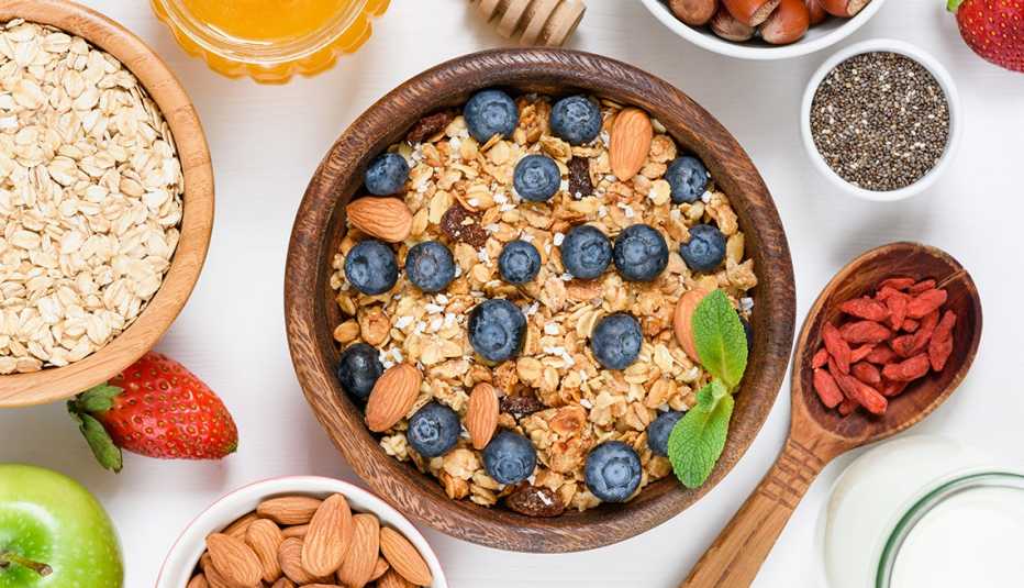 Granola con moras azules y otros alimentos alrededor