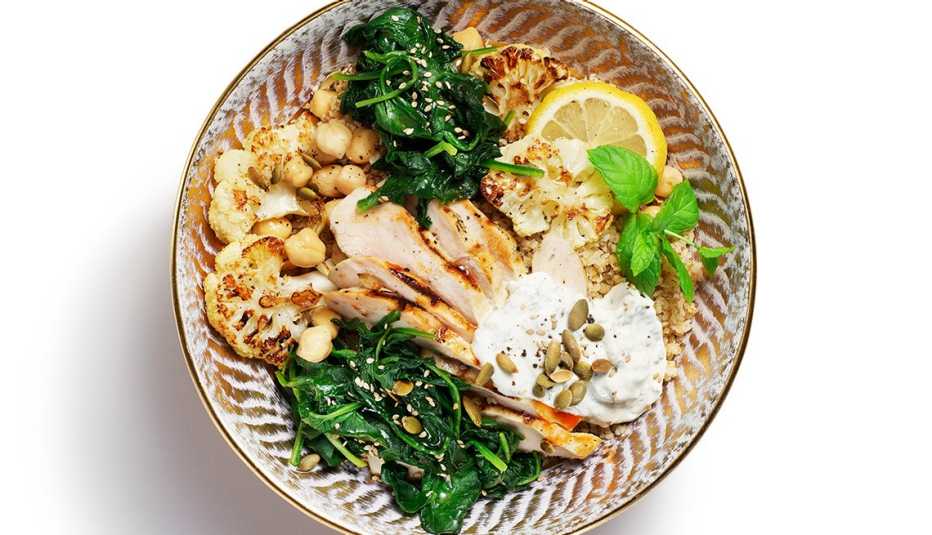 Un plato de comida del Medio Oriente con berenjenas, espinacas y guisantes
