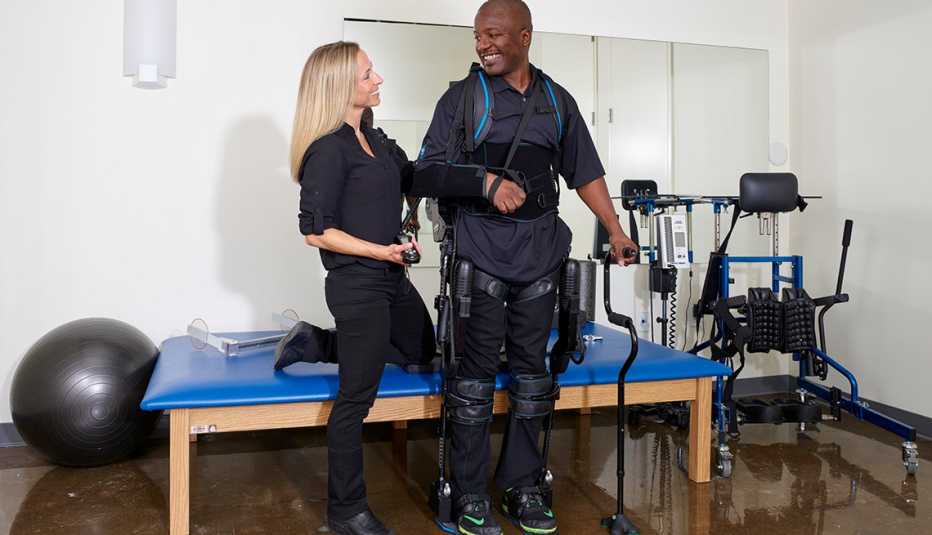 Terapeuta físico ayuda a una persona que entrena con Eksogt
