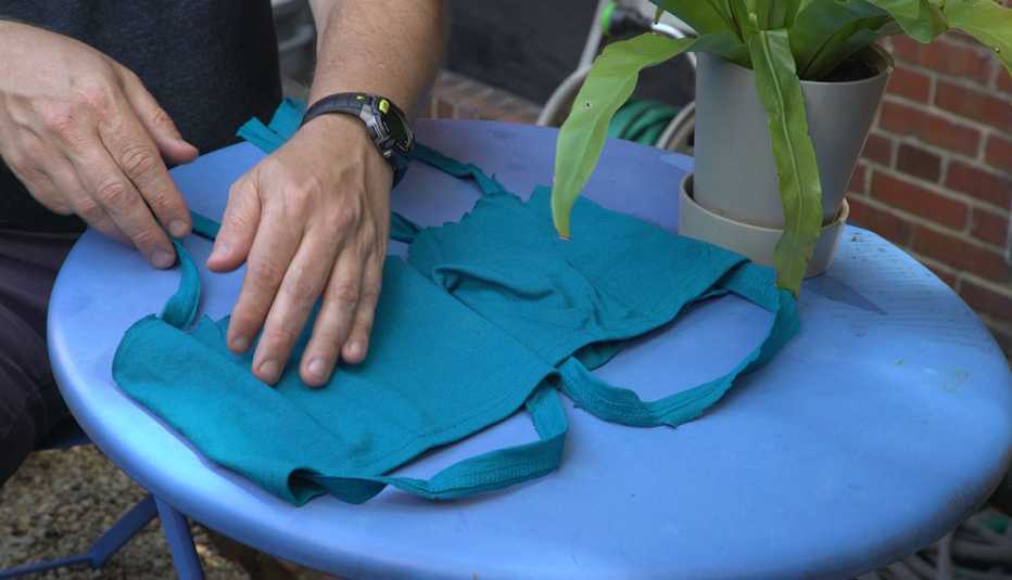 Una persona hace una mascarilla con pedazos de una camisa
