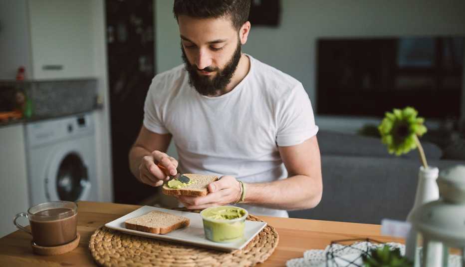 Hombre come tostadas con aguacate