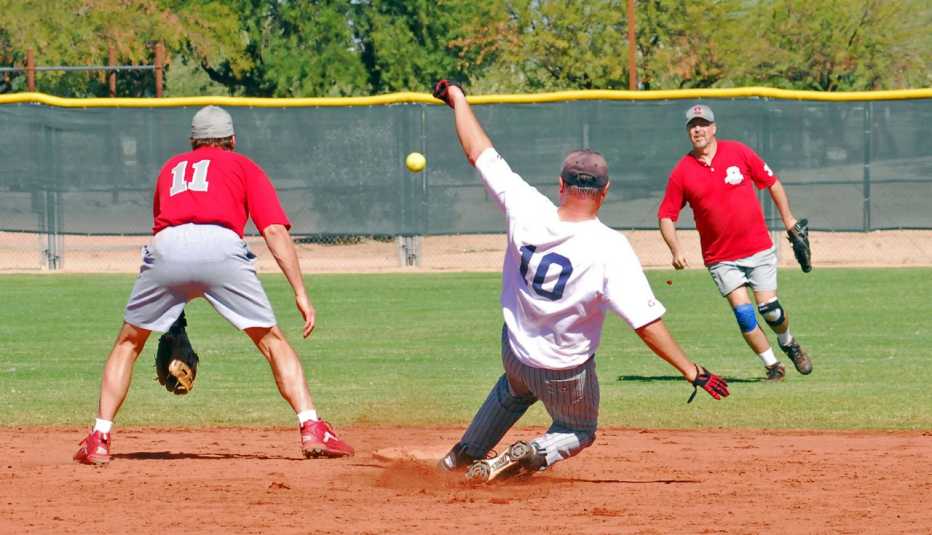 Terry Hennessy se desliza hacia segunda base en un juego de béisbol 