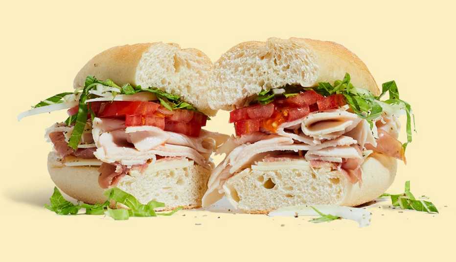 Sándwich con jamón de pavo, queso suizo, tomate y lechuga cortado a la mitad