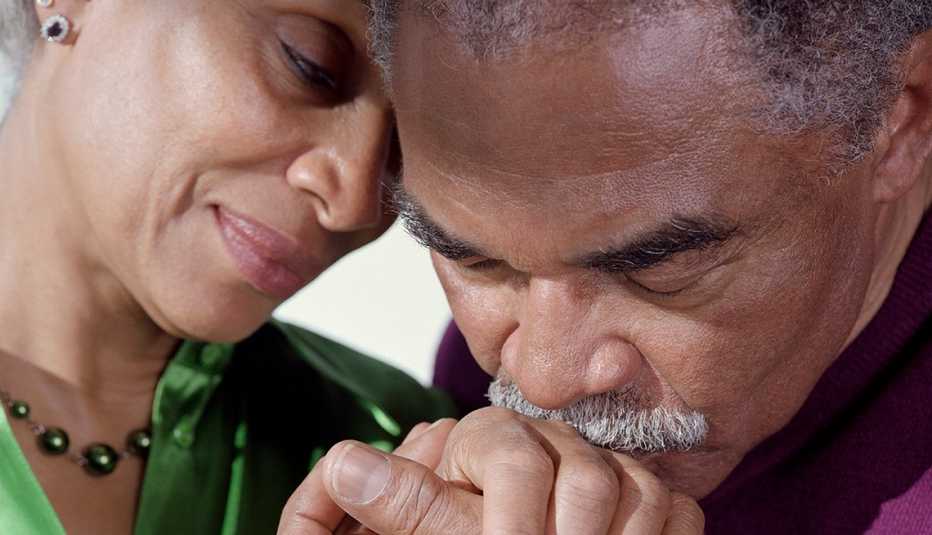 Un hombre besa con amor la mano de su esposa