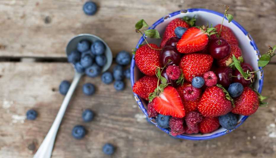Fresas, frambuesas, arándanos y cerezas en un plato hondo