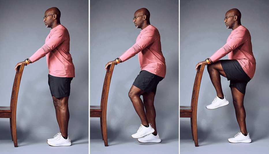 El entrenador personal Archie Israel demuestra un movimiento de equilibrio con una sola pierna mientras se apoya en una silla