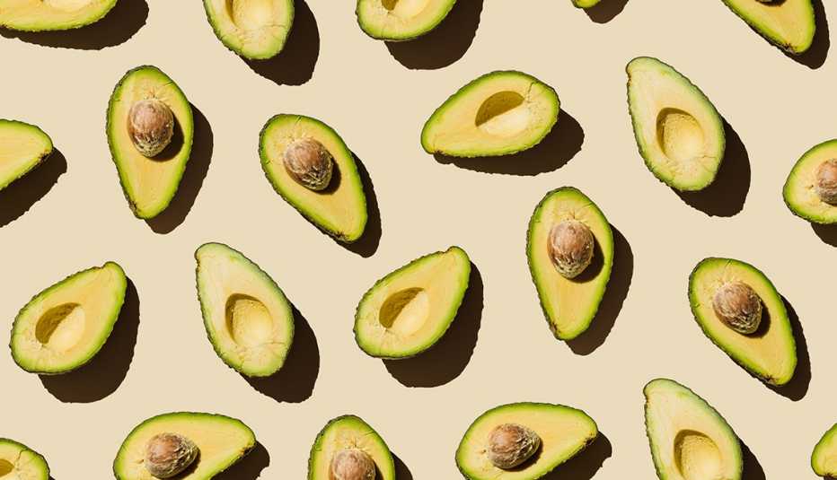 Varios aguacates cortados a la mitad colocados hacia arriba