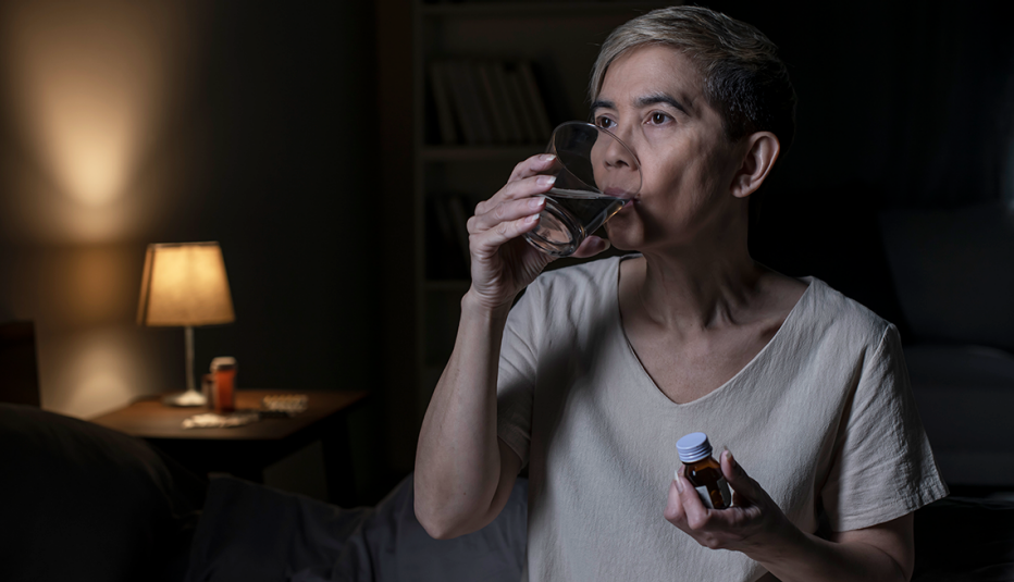 Una mujer toma un suplemento para dormir