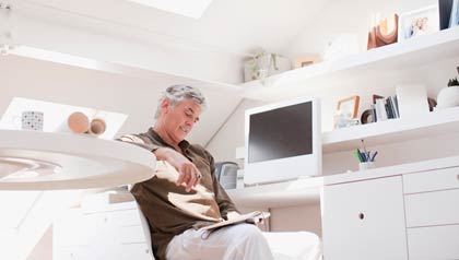 Hombre leyendo unos libros desde su casa