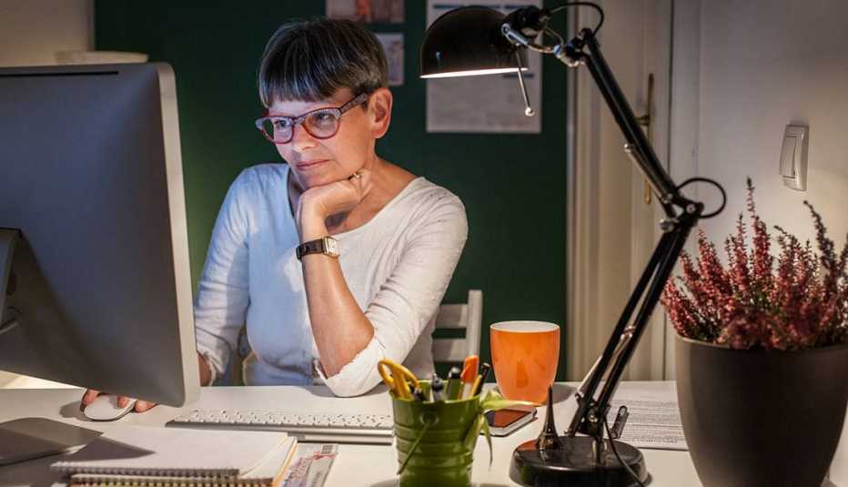 Mujer mayor frente a su computadora en casa