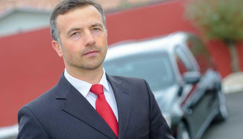 Hombre usando un traje de corbata frente a un carro funerario - Empleos con un salario anual superior a los 100 mil dólares