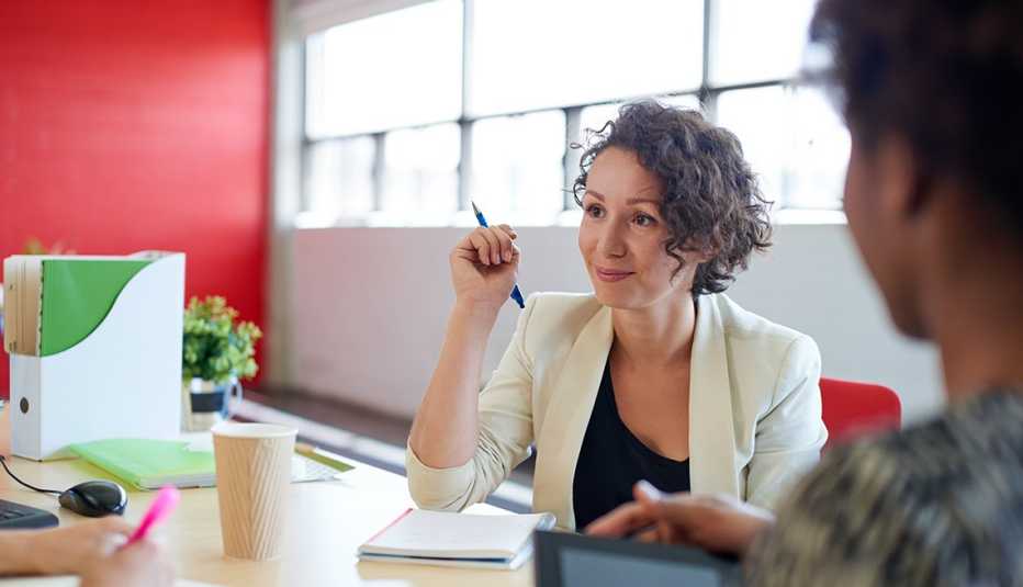 Mujer en una sala de juntas iluminada con luz natural - Empleos con un salario anual superior a los 100 mil dólares