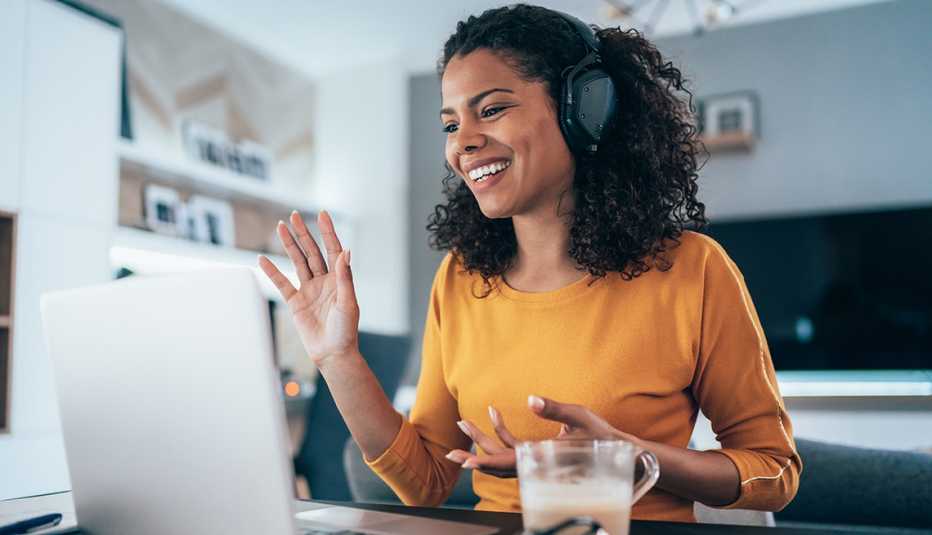 Mujer participando en una videoconferencia desde su computadora en casa.