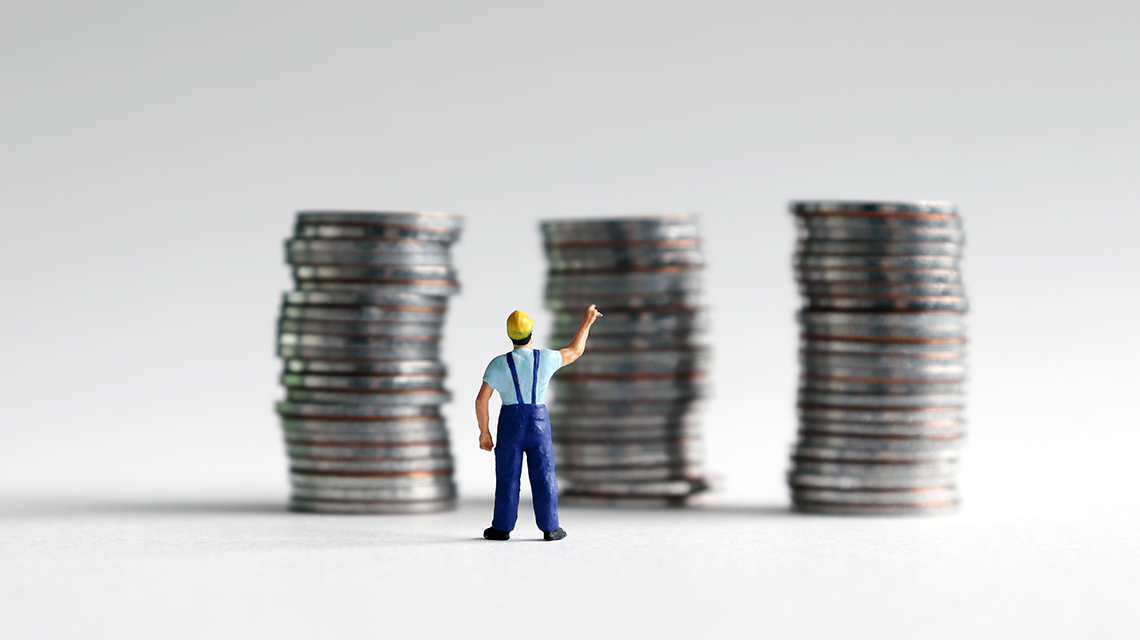 Imagen miniatura de un hombre frente a tres columnas de monedas apiladas
