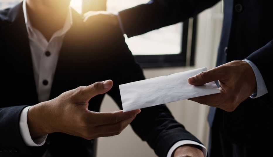 Hombre entrega un sobre como un bono laboral mientras le da una palmada en la espalda