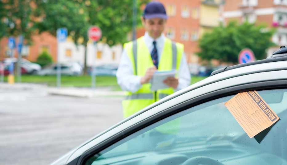 Policía de tránsito mientras coloca una infracción a un automóvil sin pasajero