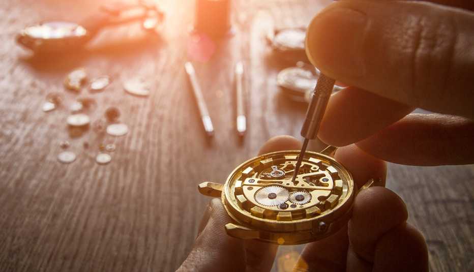 Relojero arreglando el mecanismo de un reloj de cuerda