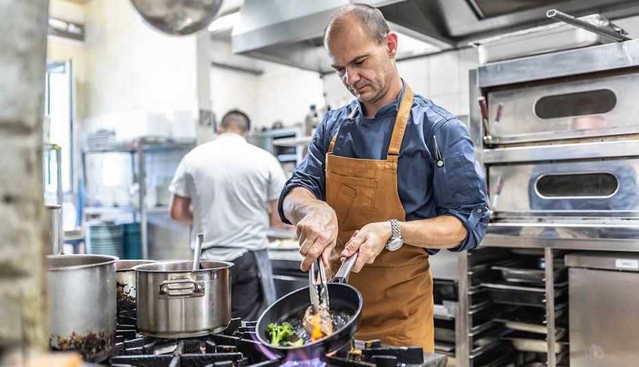 chef en una cocina industrial prepara una comida