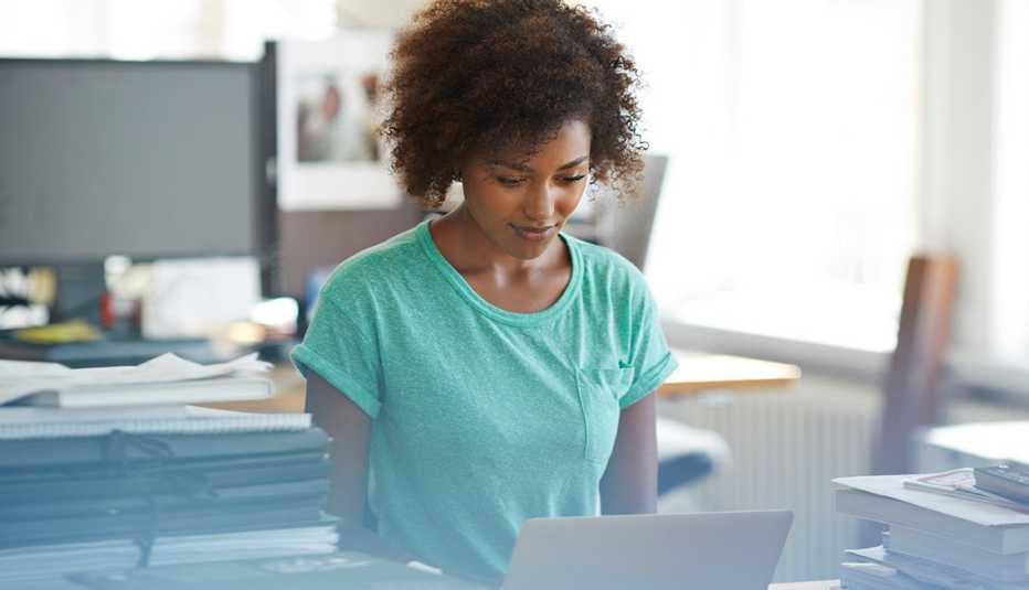 Mujer en una oficina frente a una computadora personal