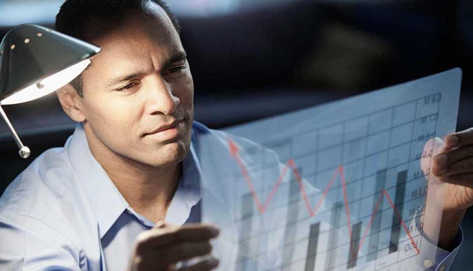 Trabajos con poco estrés, pero bien pagados, un economista mirando un gráfica con datos