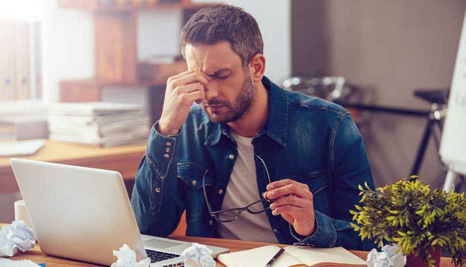 Trabajos con poco estrés, pero bien pagados, hombre frente a un computador y tocándose la cara