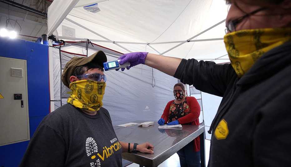 Laura Miner chequea la temperatura de Kelly Millier en Vibram Corporation, en North Brookfield, MA el 28 de abril de 2020.  