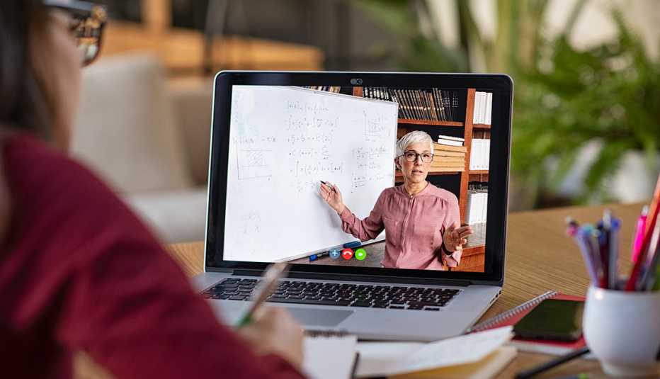 Mujer viendo una clase en línea en su casa.