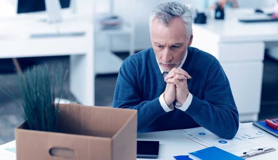 Hombre con una caja encima de su escritorio de trabajo