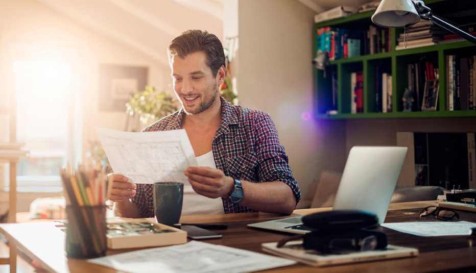 Hombre en su oficina en casa y aprende los consejos para emprender tu propia compañía