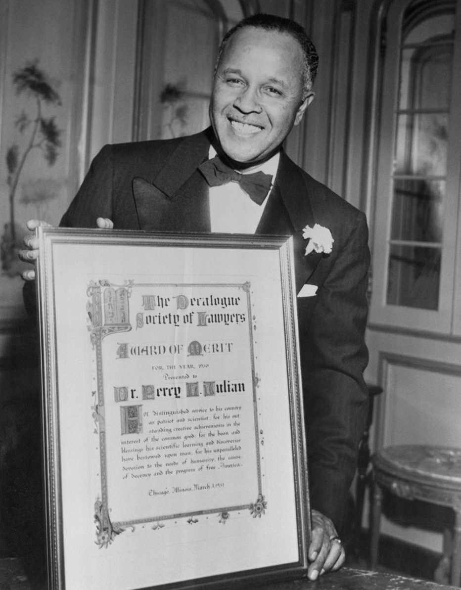 Doctor Percy Julian, químico e inventor,  sostiene un premio de Decalogue Society