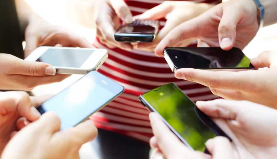 Varias manos sosteniendo diferentes modelos de teléfonos celulares