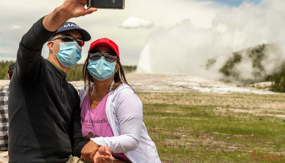 Una pareja con mascarilla quirúrgica se toma una foto
