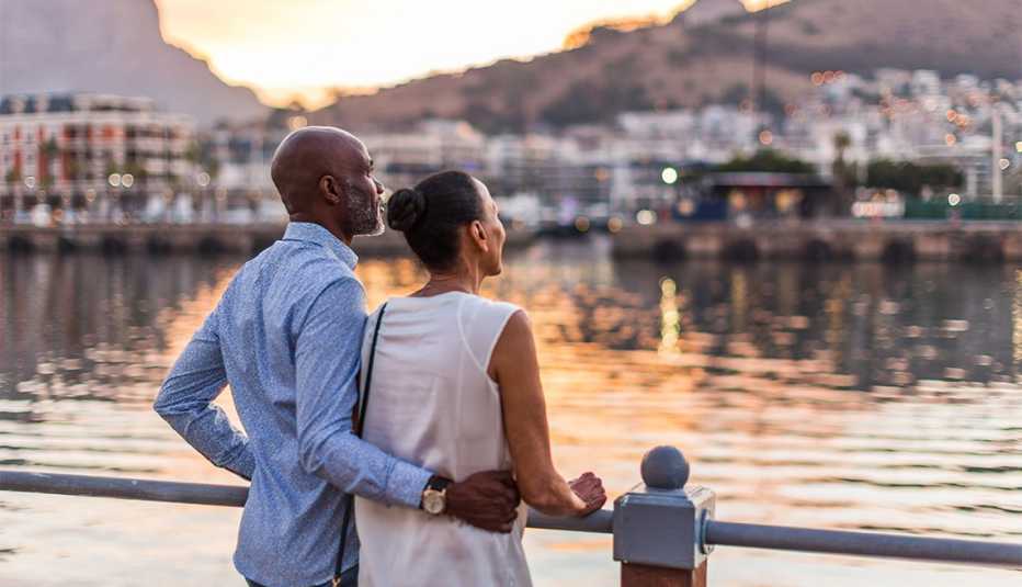 Pareja contempla la ciudad durante la puesta de sol