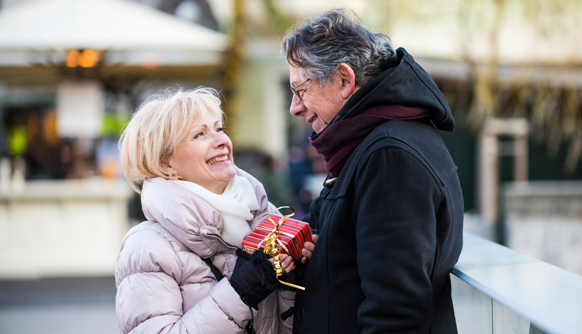 Pareja con ropa de invierno intercambia regalos