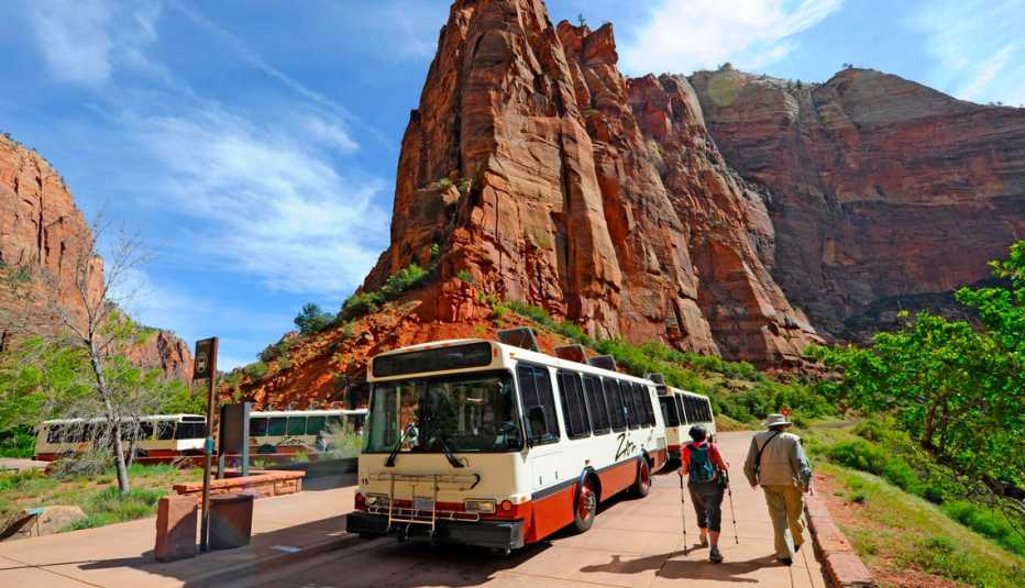 Excursionistas caminando junto a un bus turístico