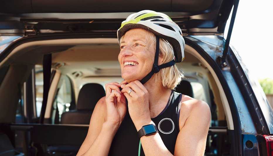 Una mujer se ajusta un casco antes de correr bicicleta
