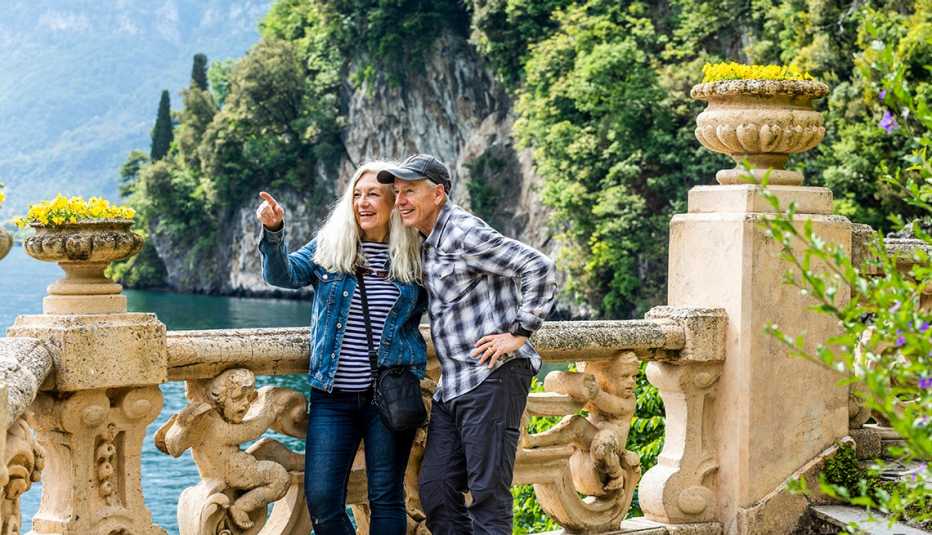 Una pareja de pie sobre una pasarela con vistas al lago de Como, Italia