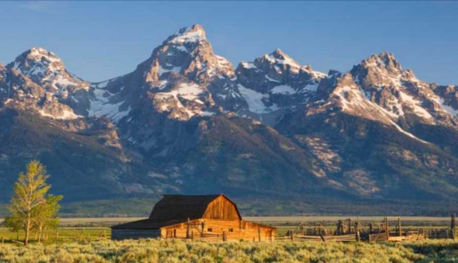 Establo de madera con grandes montañas atrás en el Parque Nacional Grand Teton, Wyoming