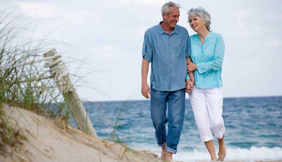 Una pareja caminando del brazo en una playa en Florida