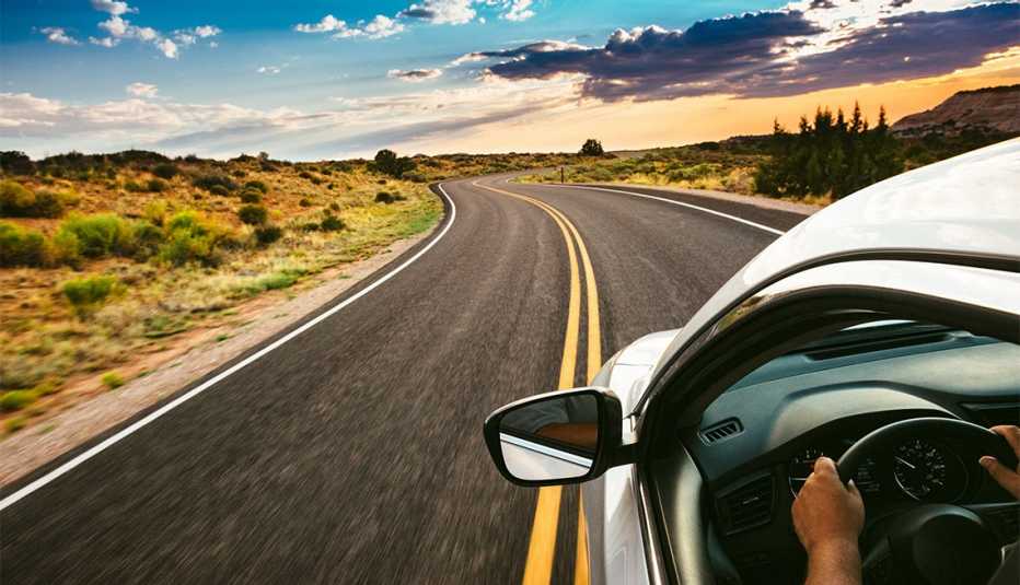 Persona al volante de un auto en una carretera